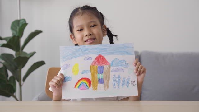 Cheerful girl shows her drawing arts picture with colored pencil