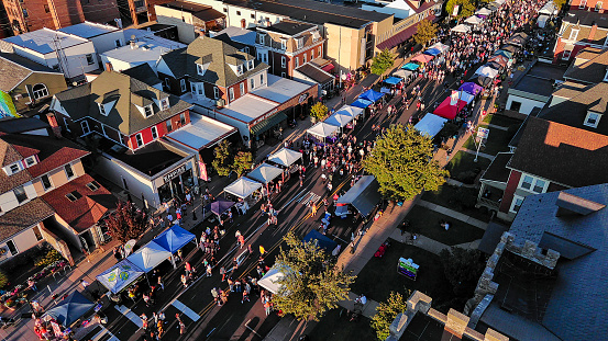 Sunny outdoor party celebrations during Fall Festival on Penn Avenue of West Reading, Pennsylvania. Drone view