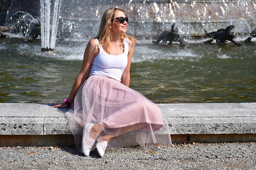Blond mature woman sitting by the fountain