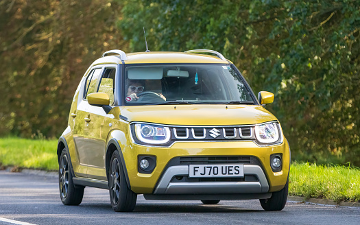Milton Keynes,UK - Sept 26th 2023: 2020 yellow Suzuki Ignis hybrid electric car driving on an English road