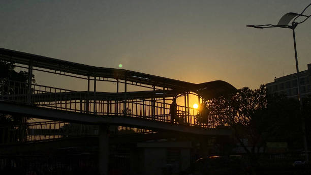 istock Silhouette of a pedestrian bridge with a sunrise background 1703328328