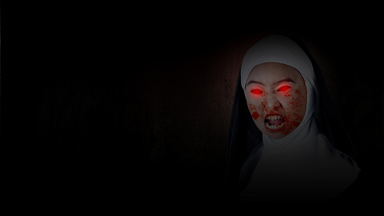 Scary devil nun standing with a dark background. Scary woman for Halloween. Halloween concept