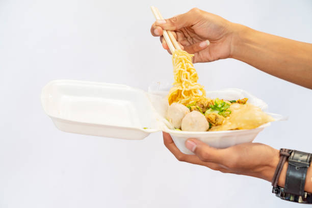 istock A human hand holding chicken noodles (mie ayam) 1703347326
