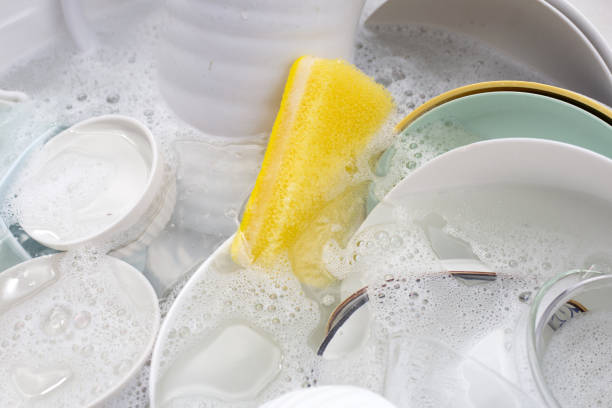 istock Dishes and bowls in water and bubbles of dishwashing liquid. Kitchen work 1703368876