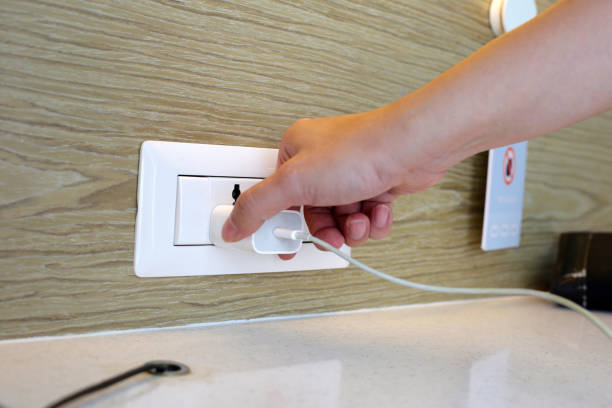 istock Hand insert a plug of the phone charger into socket. 1703420970