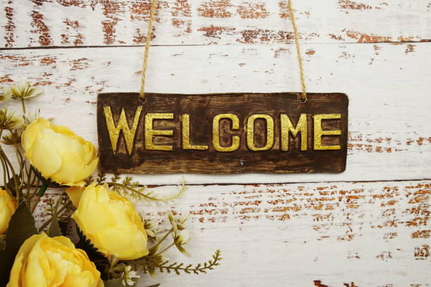 istock Welcome Sign with flowers frame decorate on wooden background 1703451068