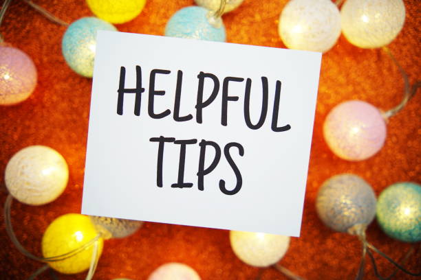 istock Helpful Tips text on paper card with LED cotton balls decoration on orange background 1703451367