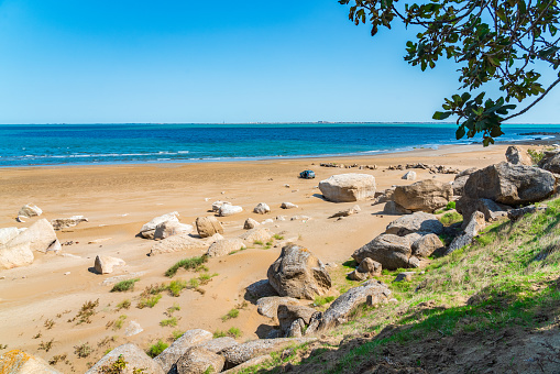 A landscape view of the coast in the distance can be seen several wind turbines out ot sea, producing green energy.