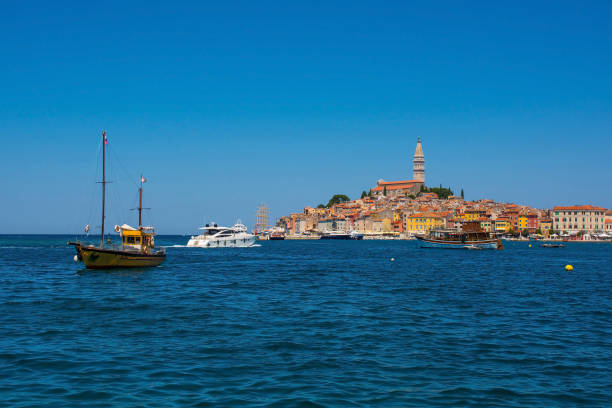 Boats on the historic waterfront of the medieval coastal town of Rovinj in Istria, Croatia. Saint Euphemia Church is centre right