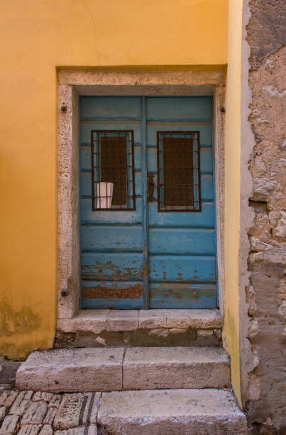 A wooden door in a quiet back street in the historic centre of the medieval coastal town of Rovinj in Istria, Croatia