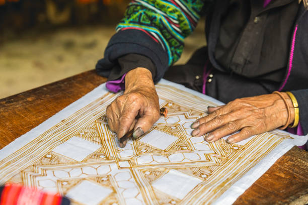 Hands of Vietnamese woman creating carpet pattern.