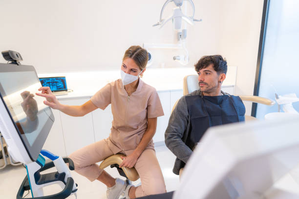 istock Dentist showing 3d image to patient sitting on a chair 1703514548