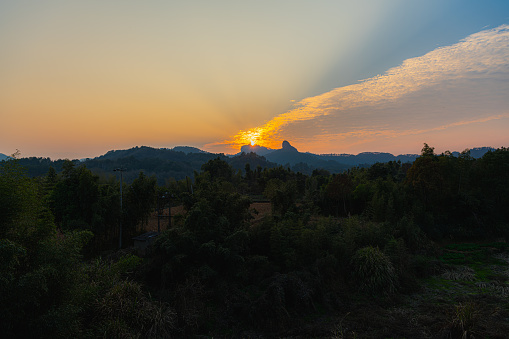 The sun setting down behind the distant mountains in Wuyishan, Fijian, China. Copy space for text, horizontal