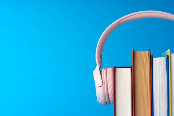 istock Pink headphones on stack of books against blue background 1703526785