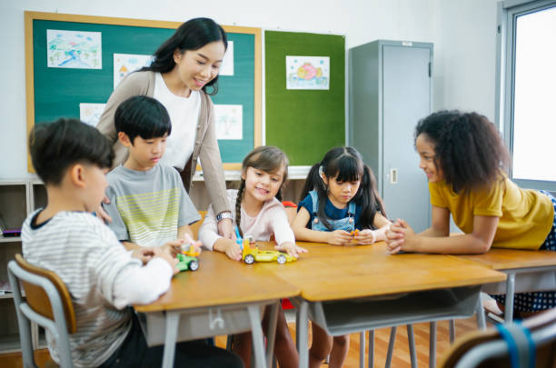 asiatische lehrerin und schüler verschiedener schüler grundschule, die während einer robotikklasse im naturwissenschaftlichen unterricht eine kollaborative projektteamarbeit durchführen. bildung, lernen, wissenschaftliches workshop-konzept. - korea child baby asian culture stock-fotos und bilder