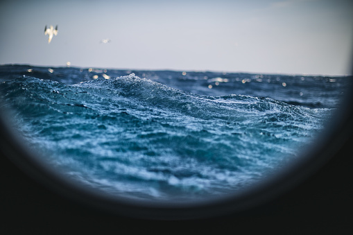 From the porthole window of a vessel in a rough sea
