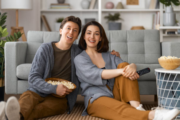 istock couple with popcorn sitting on sofa 1703556282