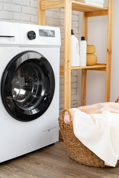 istock Laundry room with washing machine and basket with laundry 1703556878