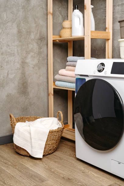 istock Laundry room interior with washing machine near gray grunge wall 1703562387