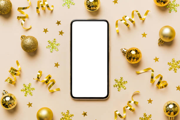 istock Christmas online shopping from home phone with blank white display top view. smart mobile with copy space on colored background with Christmas decorations balls,. Winter holidays sales background 1703581701