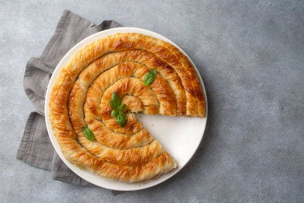 istock Turkish Tepsi Boregi, Round Borek, Tray pastry (Turkish name; rulo borek - ispanakli borek) 1703583433