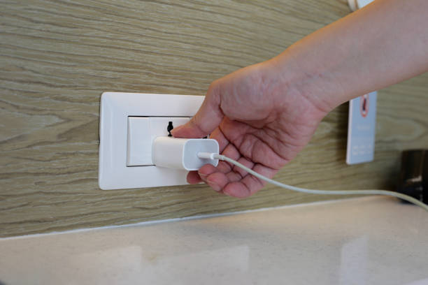 istock Hand insert a plug of the phone charger into socket. 1703587246