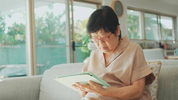 istock Asian senior woman using digital tablet at home, working senior, elderly using technology concept 1703591149