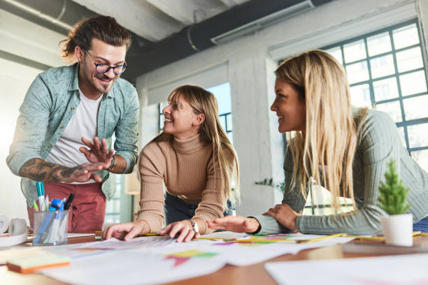 istock Team of happy freelancers talking while analyzing plans in the office. 1703603222