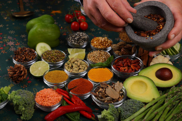 Holding vegetables over selection of herbs