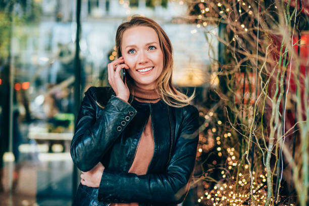 istock Cheerful woman using cell phone on the street. 1703628110