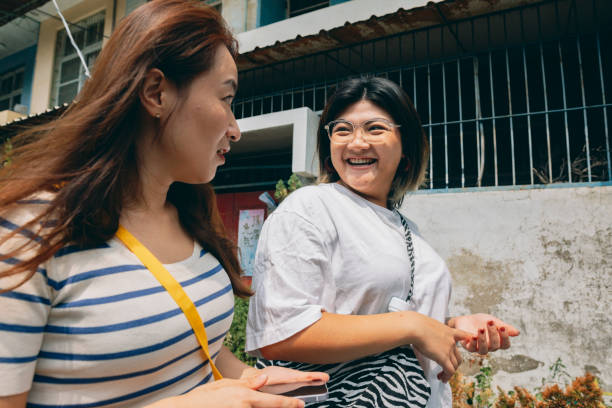 2人のアジア人女性が一緒に買い物に行き、家に帰り、楽しくおしゃべりをしながら、日常生活の喜びを分かち合います。 - short paste ストックフォトと画像