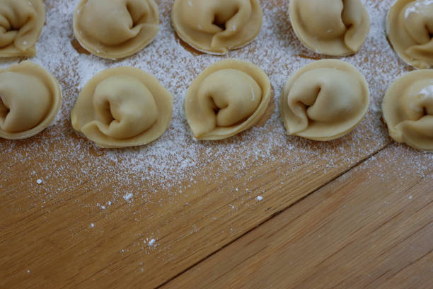 istock Italian Cappellacci pasta in rows  on wooden table 1703658301