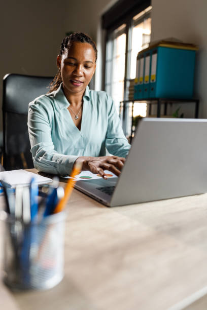 istock Diligent woman working at her desk in a small office 1703661073