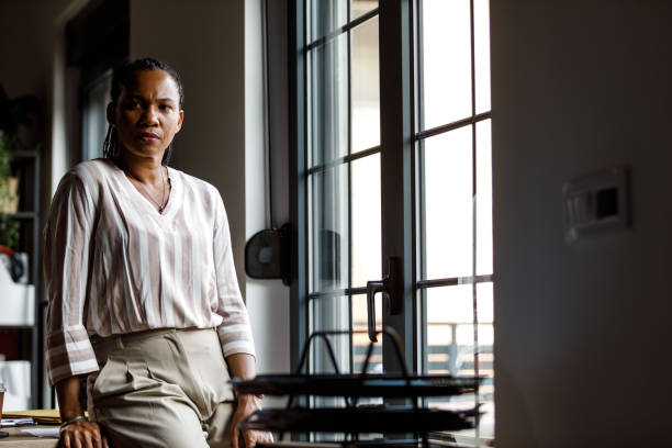 istock Leaning against her desk, looking out the window and contemplating a work break 1703661645
