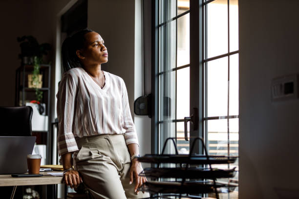 istock Leaning against her desk, looking out the window and contemplating a work break 1703661649