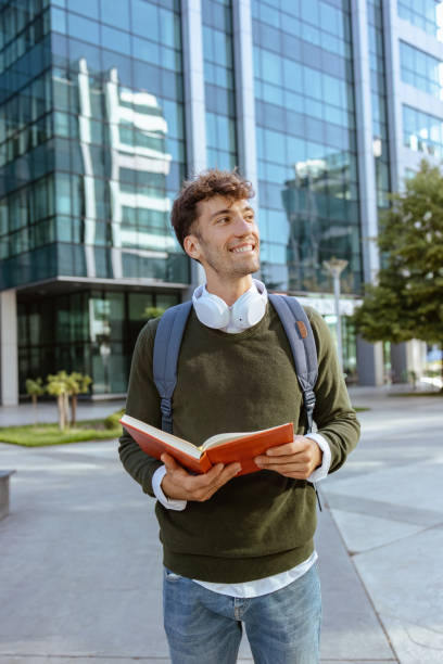 istock Cheerful male reading notes on the street 1703685598
