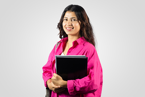 Young and Beautiful Asian Nepalese Student Abroad Study Giving gestures with notebook in hand