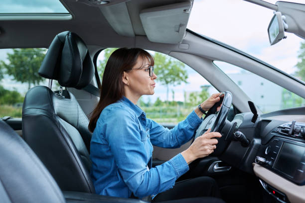 istock Middle-aged woman driver sitting behind wheel in car 1703697190