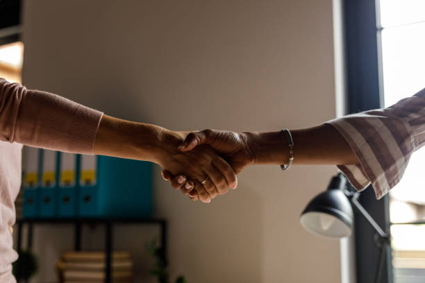 istock Two diverse women shaking hands when meeting at the office 1703720262