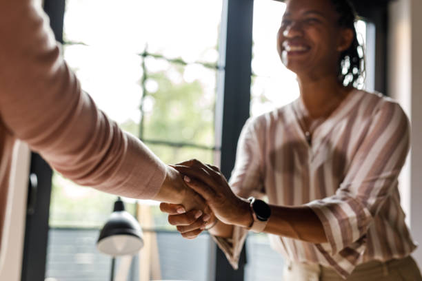 istock Two diverse women shaking hands when meeting at the office 1703720263