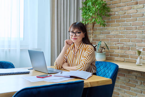 istock Middle aged business woman working in office using paper laptop 1703721333