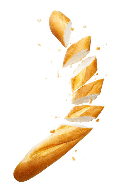 Slices of loaf of baguette with crumbs flying