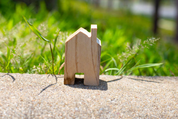 istock Miniature wooden house on green grass 1703740834
