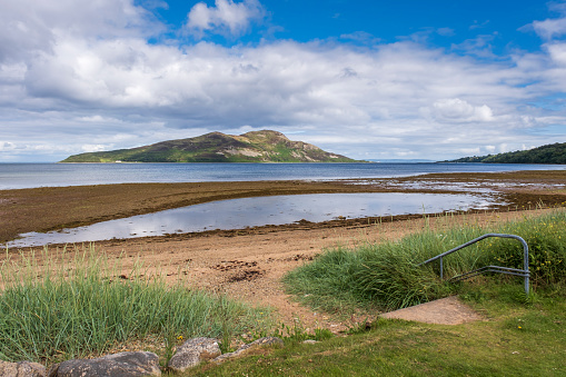 View across Lamlash beach and bay to Holy Island from Lamlash on the Isle of Arran, Scotland.
