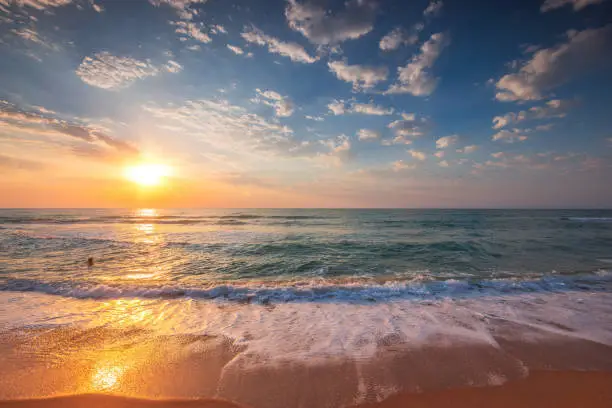 Photo of Beautiful tropical sunrise over the sea horizon and beach shore