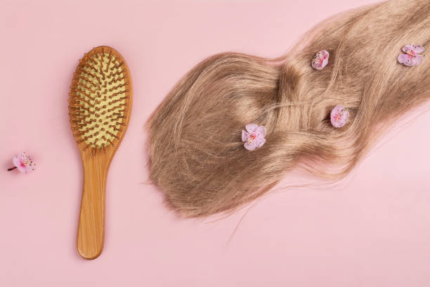 istock Long blond hair with sakura flowers on pink background 1703773600