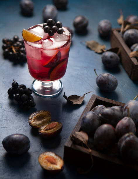 istock Iced drink with plums a grape on the blue table with plums and sliced plums around 1703777581