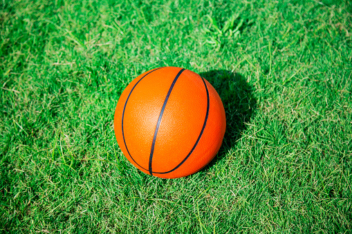 basketball ball on a green grass with copy space