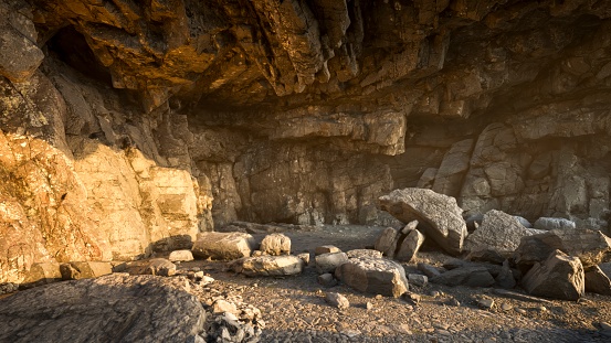 The cave's rocky ceiling permits the warm, golden radiance of the setting sun to filter through, gently illuminating the cave floor with a soft glow.