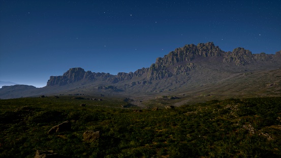 Under the canopy of the night sky, the mountain fields create a tranquil and picturesque scene.